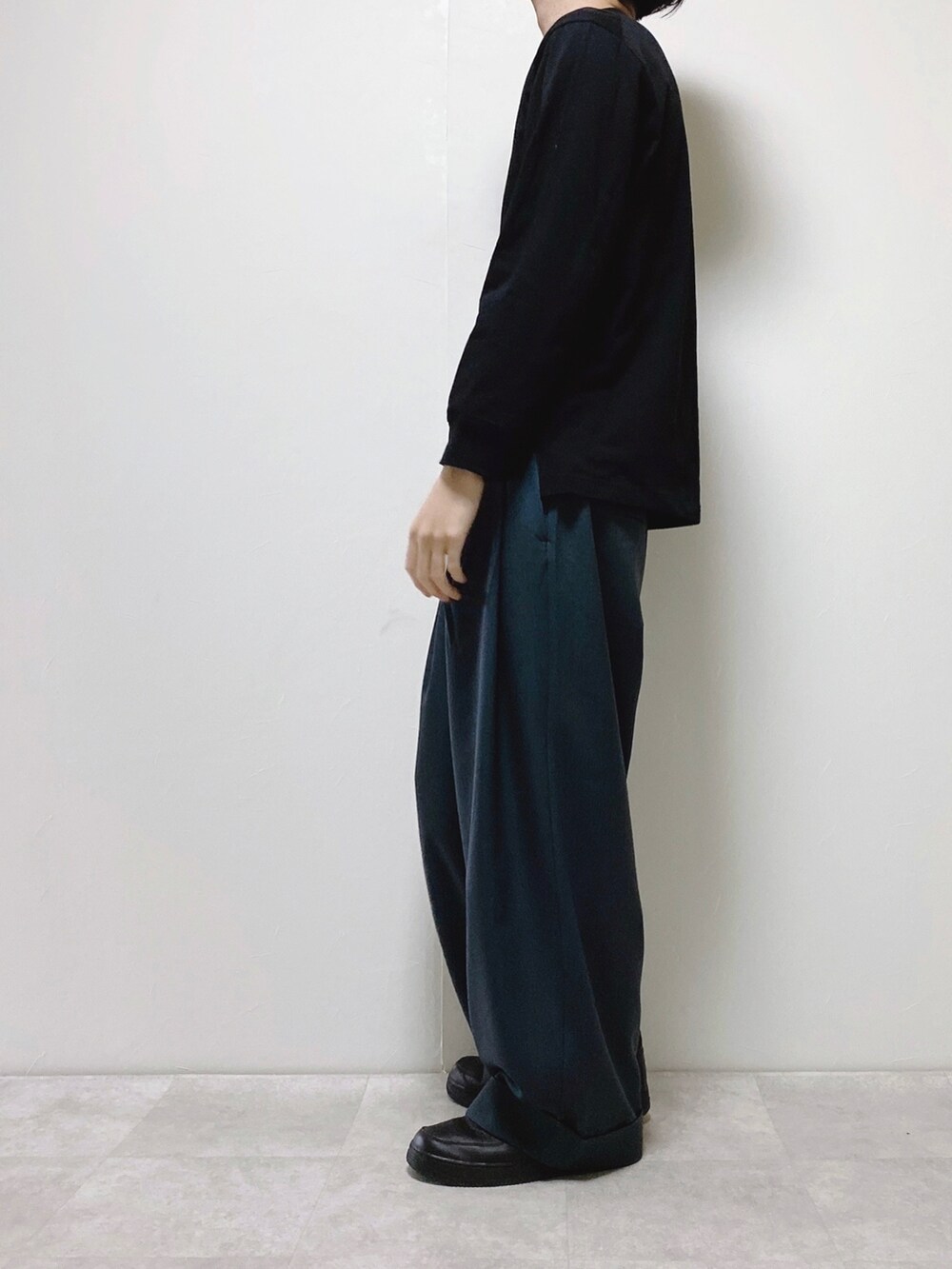 ブルー系のスラックス、ベージュ系のカーディガン/ボレロ、ブラック系のTシャツ/カットソーを着用したメンズの春コーディネートの2枚目の写真