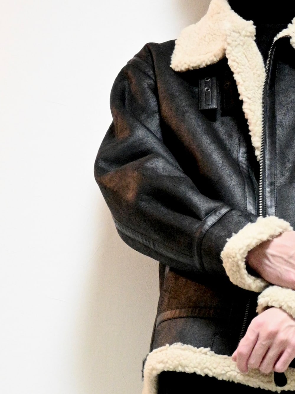 ブラック系のムートンコート、ブラック系のスラックスを着用したメンズの秋コーディネートの2枚目の写真