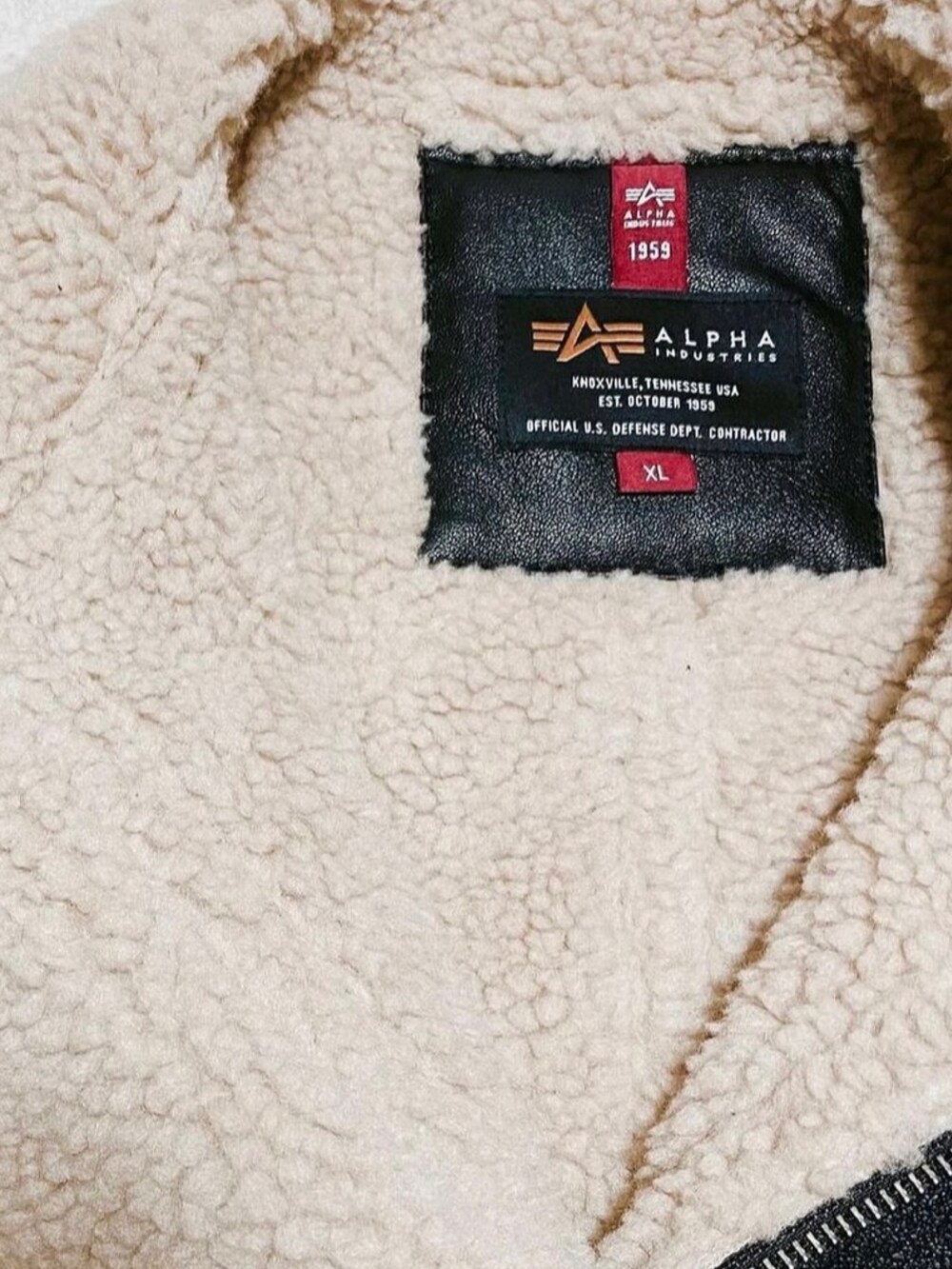 ブラック系のムートンコート、ブルー系のデニムパンツ、ブラック系のスニーカーを着用したメンズの秋コーディネートの2枚目の写真