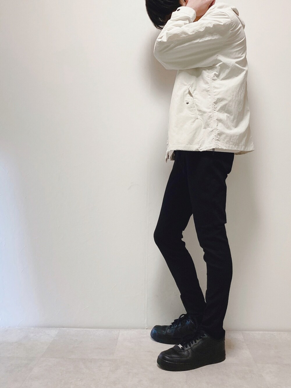 ホワイト系のマウンテンパーカー、ブラック系のデニムパンツ、ブラック系のスニーカーを着用したメンズの春コーディネートの2枚目の写真