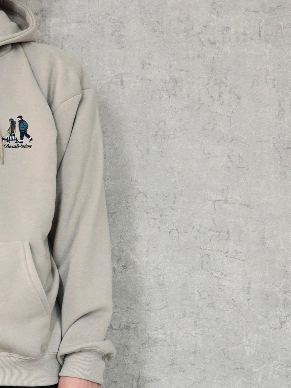 ベージュ系のパーカー、ブラック系のトートバッグ、ブラック系のスニーカーを着用したメンズの春コーディネートの2枚目の写真