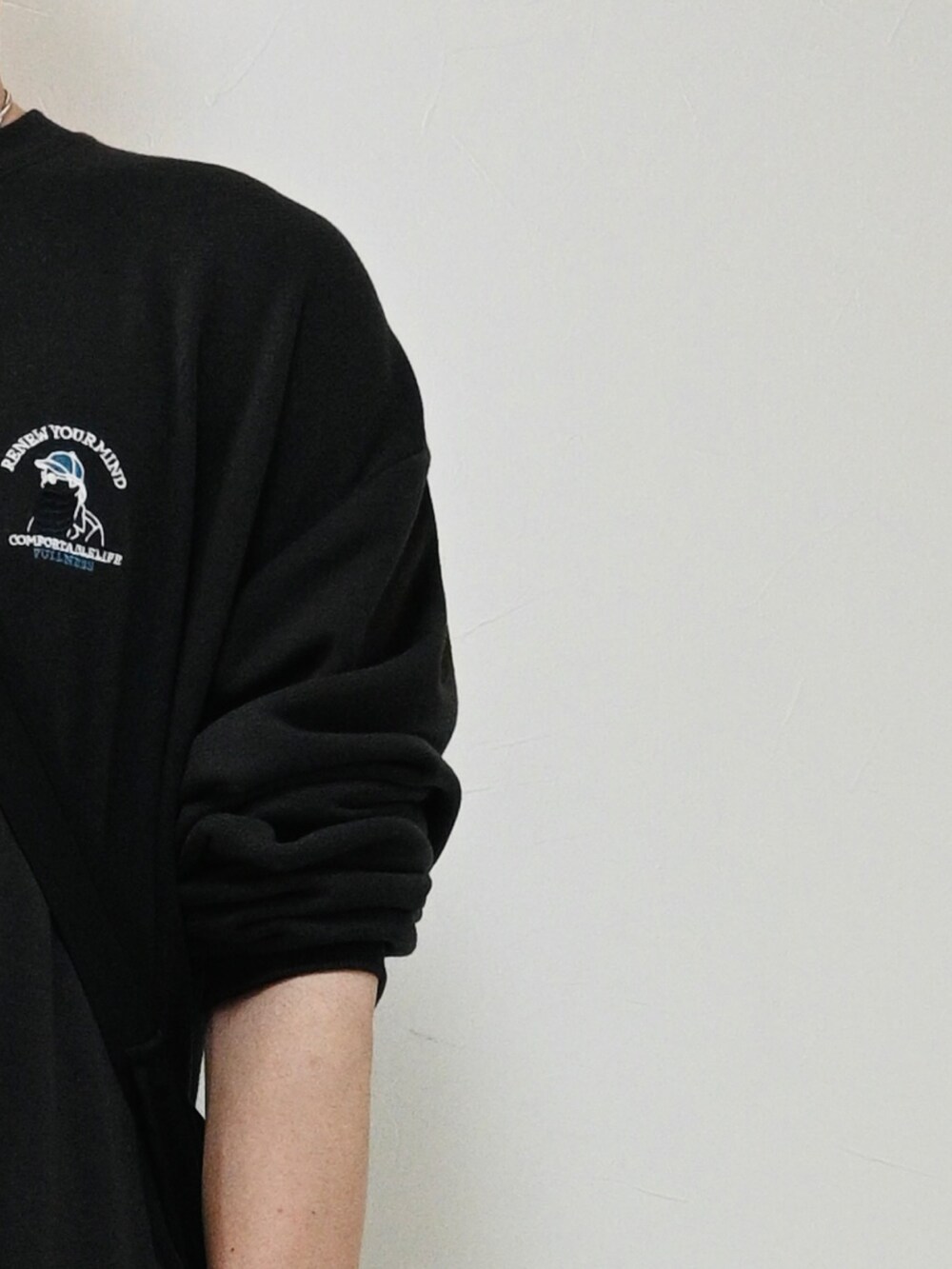 ブラック系のスウェット、ブルー系のデニムパンツ、ブラック系のショルダーバッグを着用したメンズの秋コーディネートの2枚目の写真