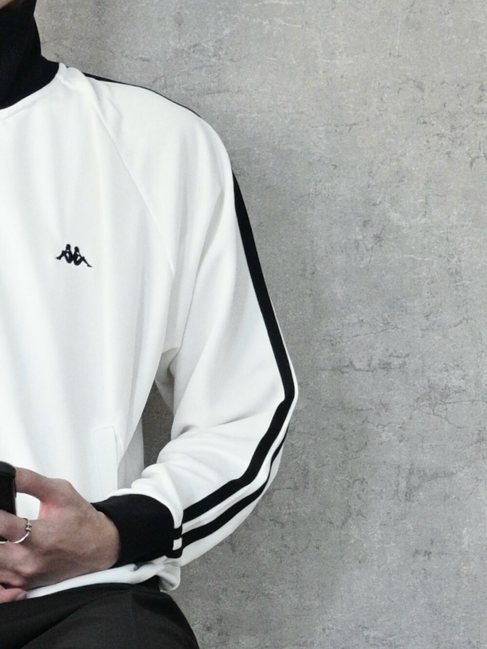 ホワイト系のジャージ、ブラック系のデニムパンツ、ブラック系のスニーカーを着用したメンズの秋コーディネートの2枚目の写真