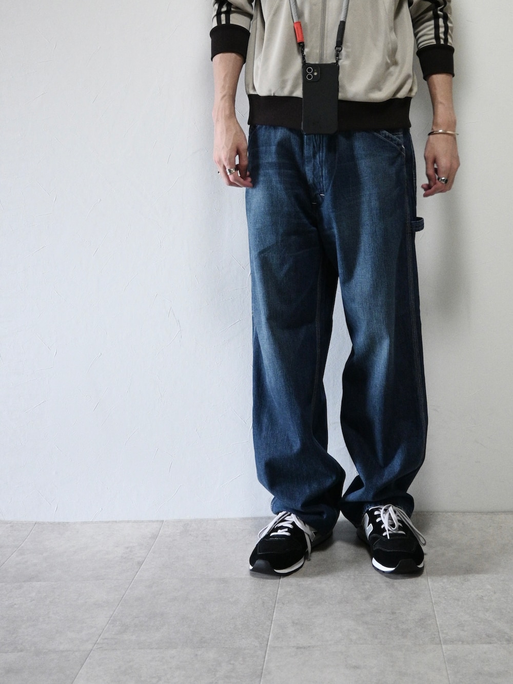 ベージュ系のジャージ、ブルー系のデニムパンツ、ブラック系のスニーカーを着用したメンズの秋コーディネートの3枚目の写真