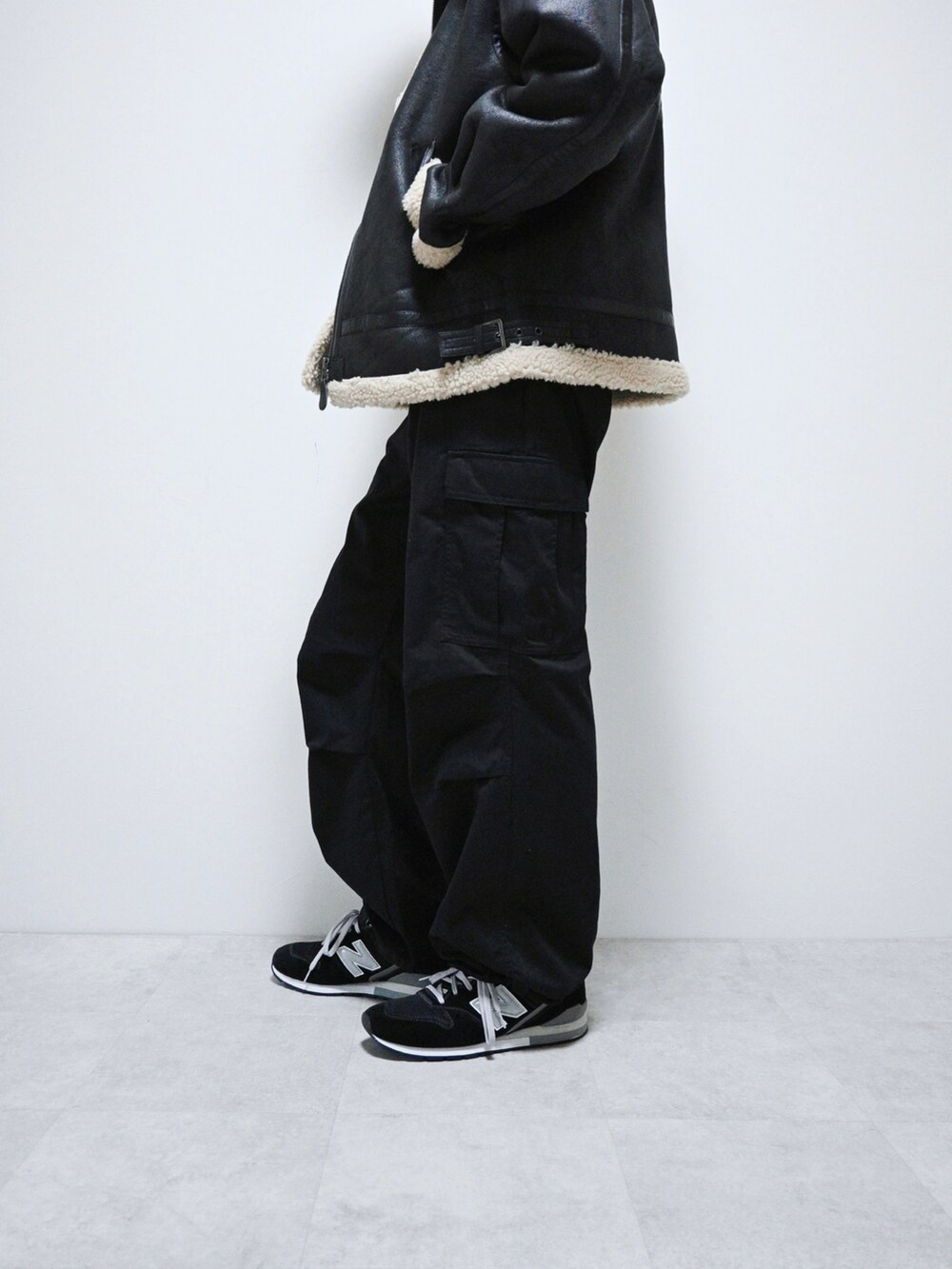 ブラック系のカーゴパンツ、グリーン系のパーカー、ブラック系のムートンコートを着用したメンズの冬コーディネートの2枚目の写真