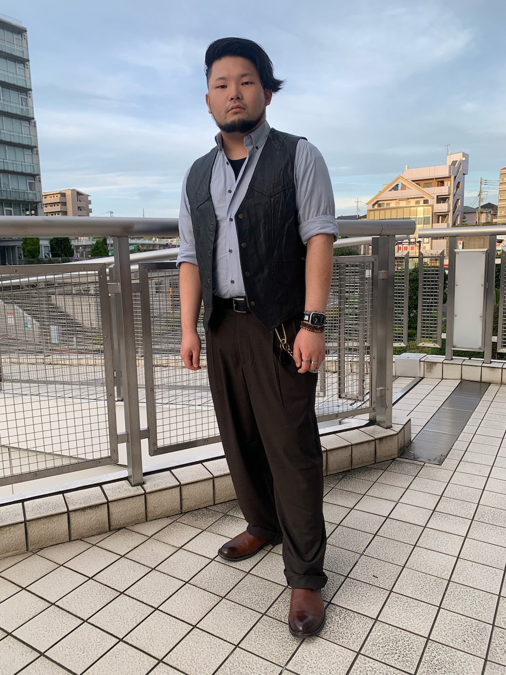 ブラック系のスーツベスト、ブラウン系のスラックス、ブラウン系のブーツを着用したメンズの夏コーディネートの3枚目の写真