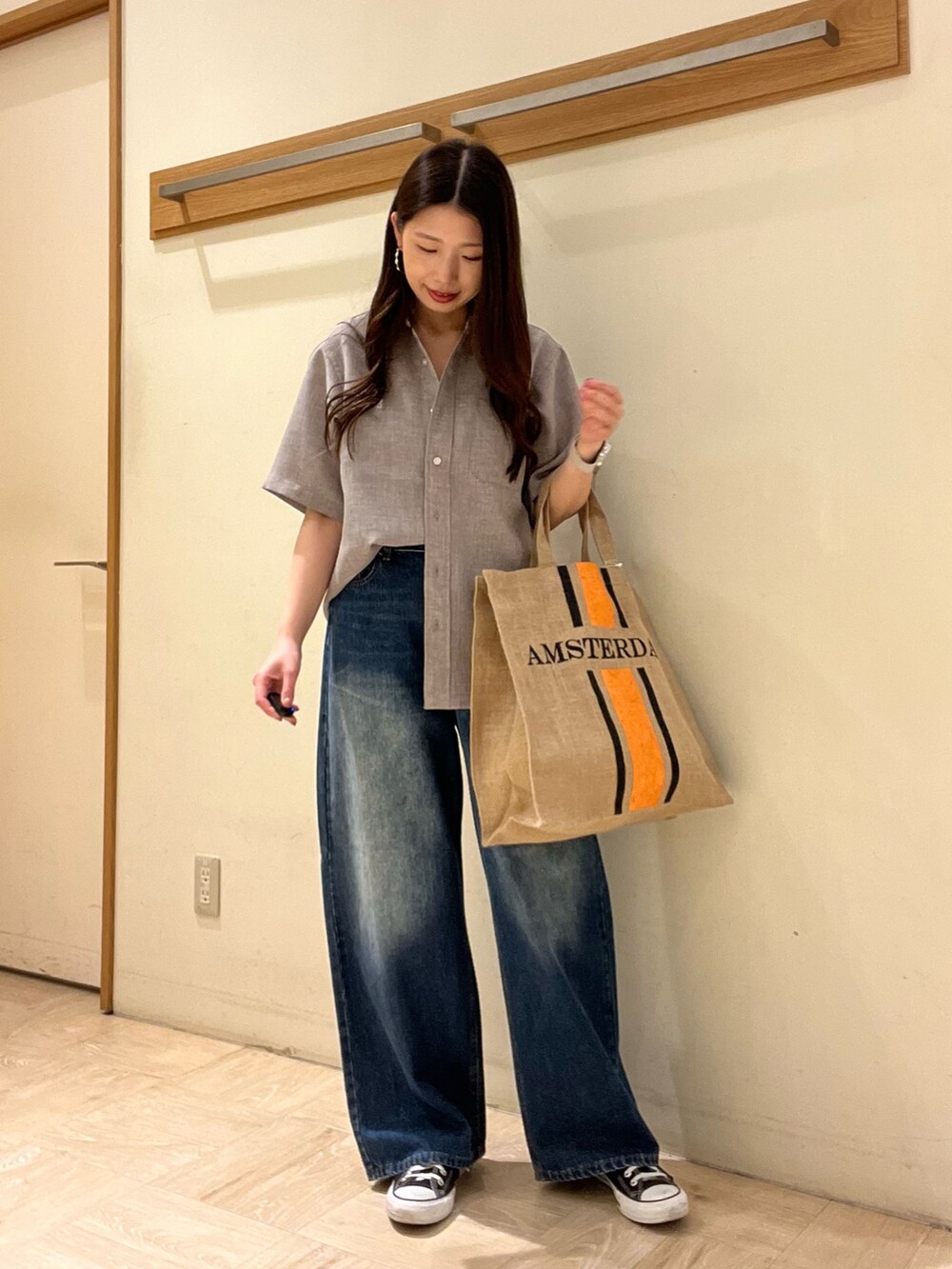 ベージュ系のシャツ/ブラウス、ブルー系のデニムパンツ、ブラック系のトートバッグを着用したレディースの夏コーディネートの3枚目の写真