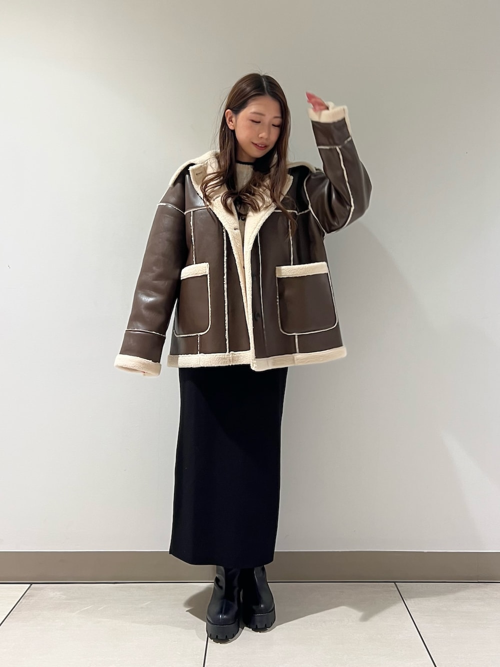 ブラック系のブーツ、ブラック系のデニムパンツ、ブラック系のトートバッグを着用したレディースの冬コーディネートの4枚目の写真