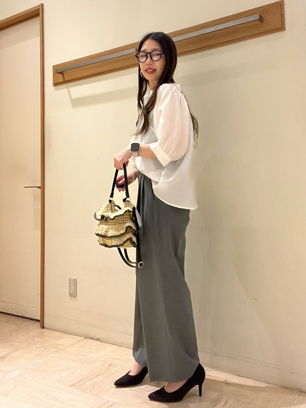 ホワイト系のシャツ/ブラウス、グレー系のスラックス、ブラック系のかごバッグを着用したレディースの夏コーディネートの4枚目の写真