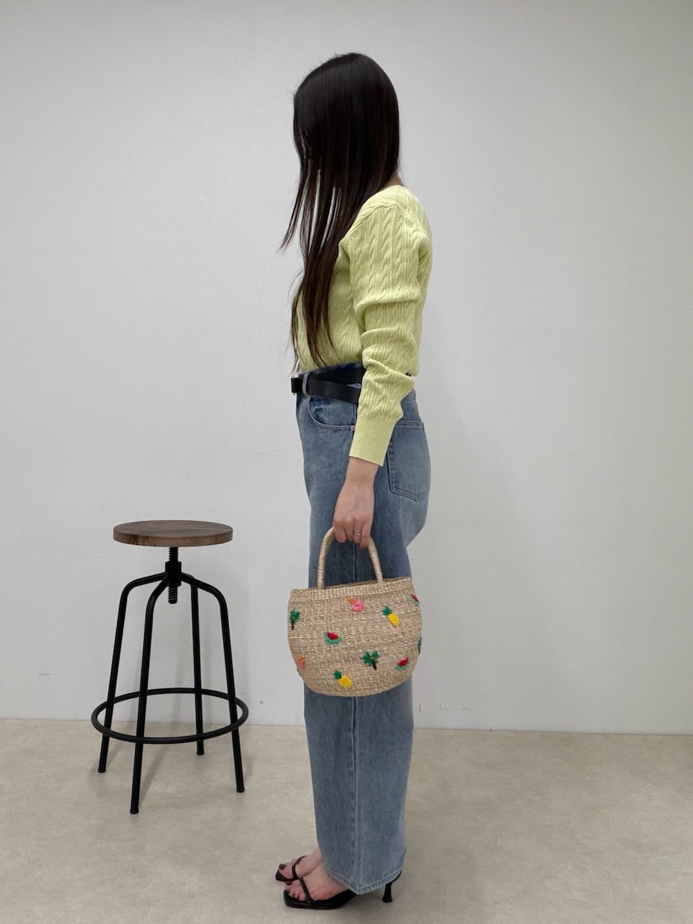 グリーン系のカーディガン/ボレロ、ブルー系のデニムパンツ、ベージュ系のかごバッグを着用したレディースの春コーディネートの3枚目の写真