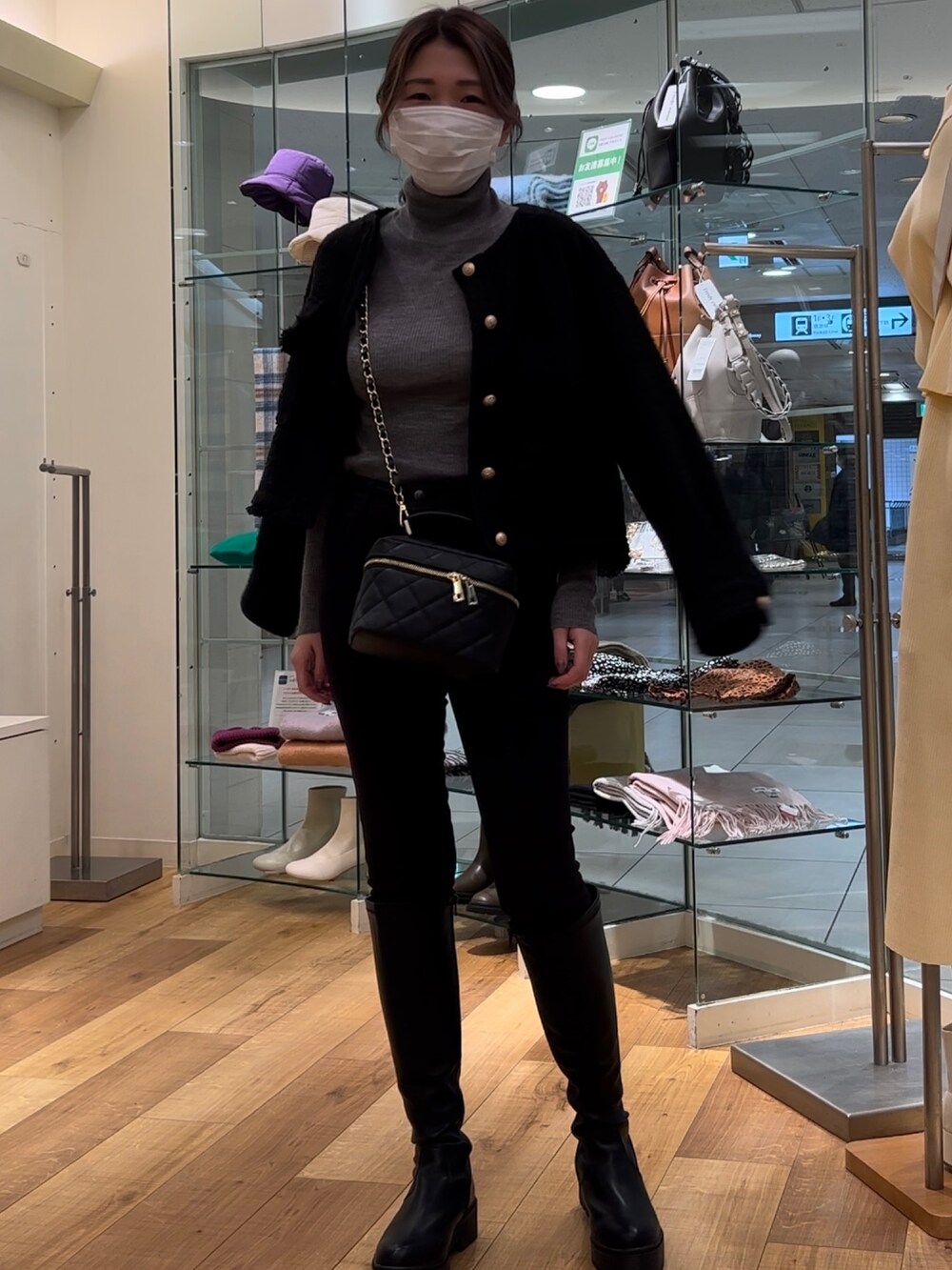 ブラック系のノーカラージャケット、ブラック系のショルダーバッグ、ブラック系のブーツを着用したレディースの冬コーディネートの3枚目の写真