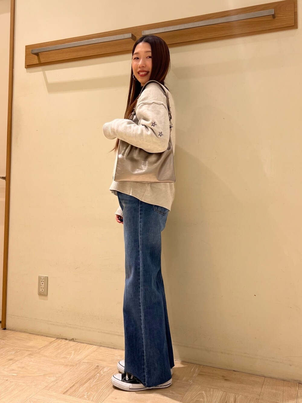 ホワイト系のカーディガン/ボレロ、ブルー系のデニムパンツ、その他のショルダーバッグを着用したレディースの冬コーディネートの4枚目の写真