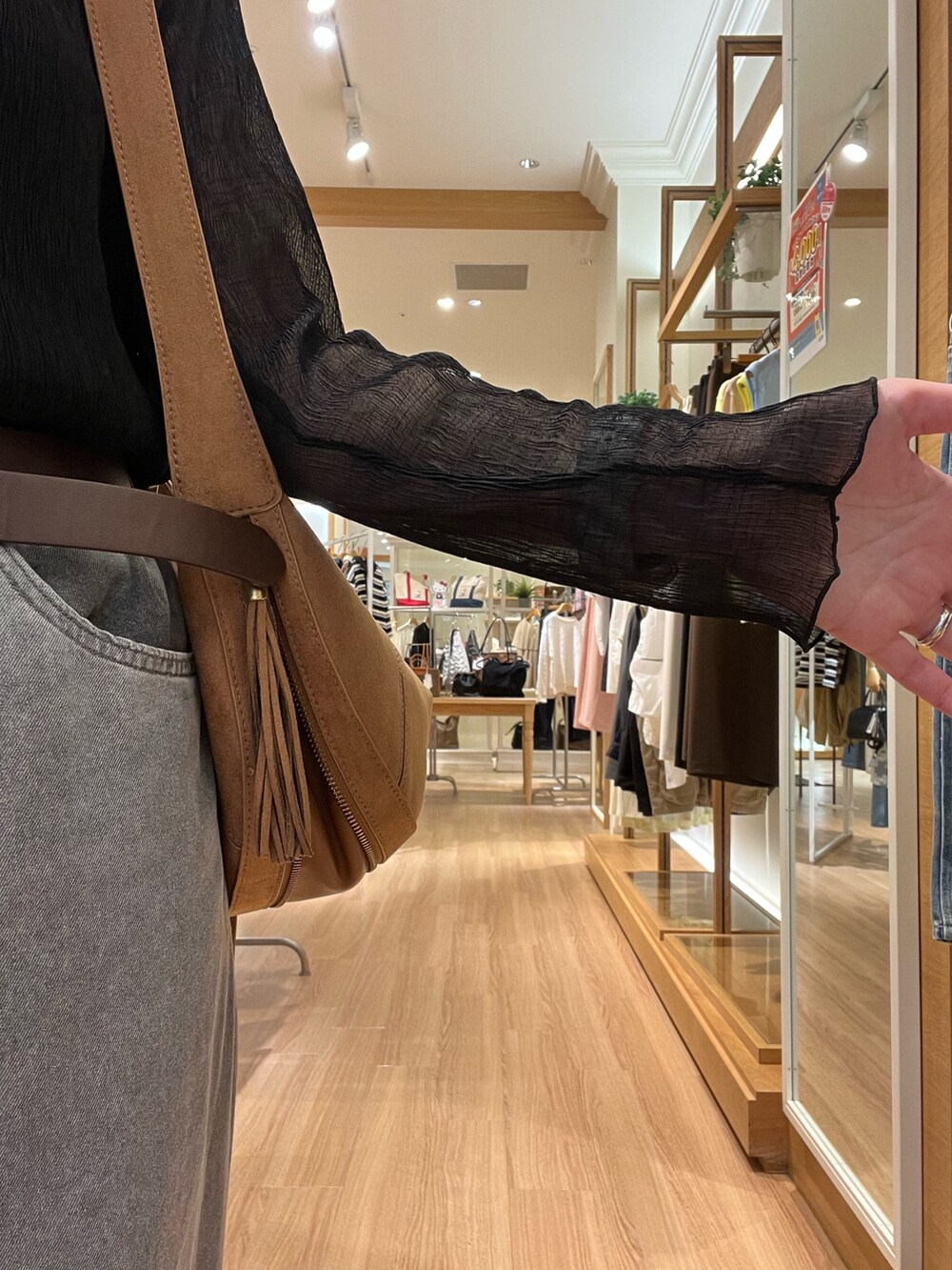 ブラック系のシャツ/ブラウス、ベージュ系のデニムパンツ、イエロー系のショルダーバッグを着用したレディースの秋コーディネートの4枚目の写真