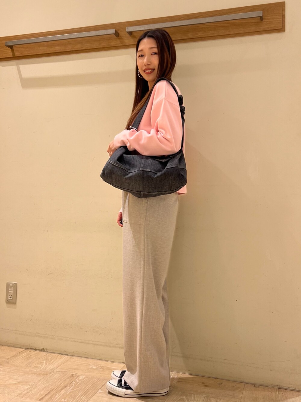 ベージュ系のその他パンツ、ピンク系のスウェット、ブラック系のショルダーバッグを着用したレディースの冬コーディネートの2枚目の写真