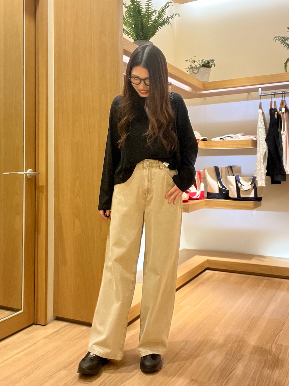 ブラック系のTシャツ/カットソー、ベージュ系のデニムパンツ、ブラック系のサングラスを着用したレディースの夏コーディネートの6枚目の写真