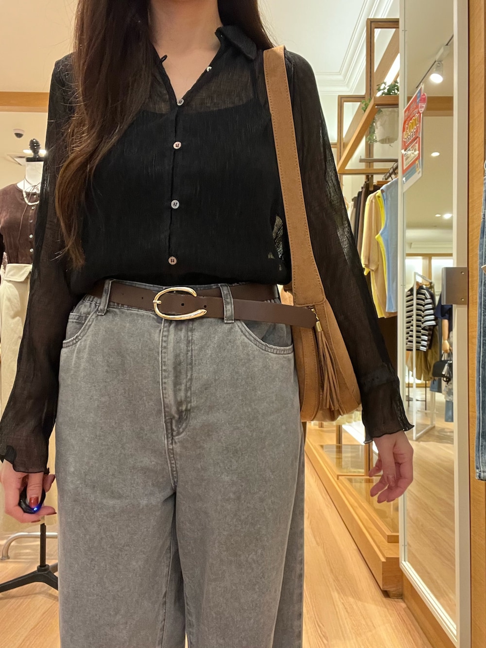 ブラック系のシャツ/ブラウス、ベージュ系のデニムパンツ、イエロー系のショルダーバッグを着用したレディースの秋コーディネートの3枚目の写真