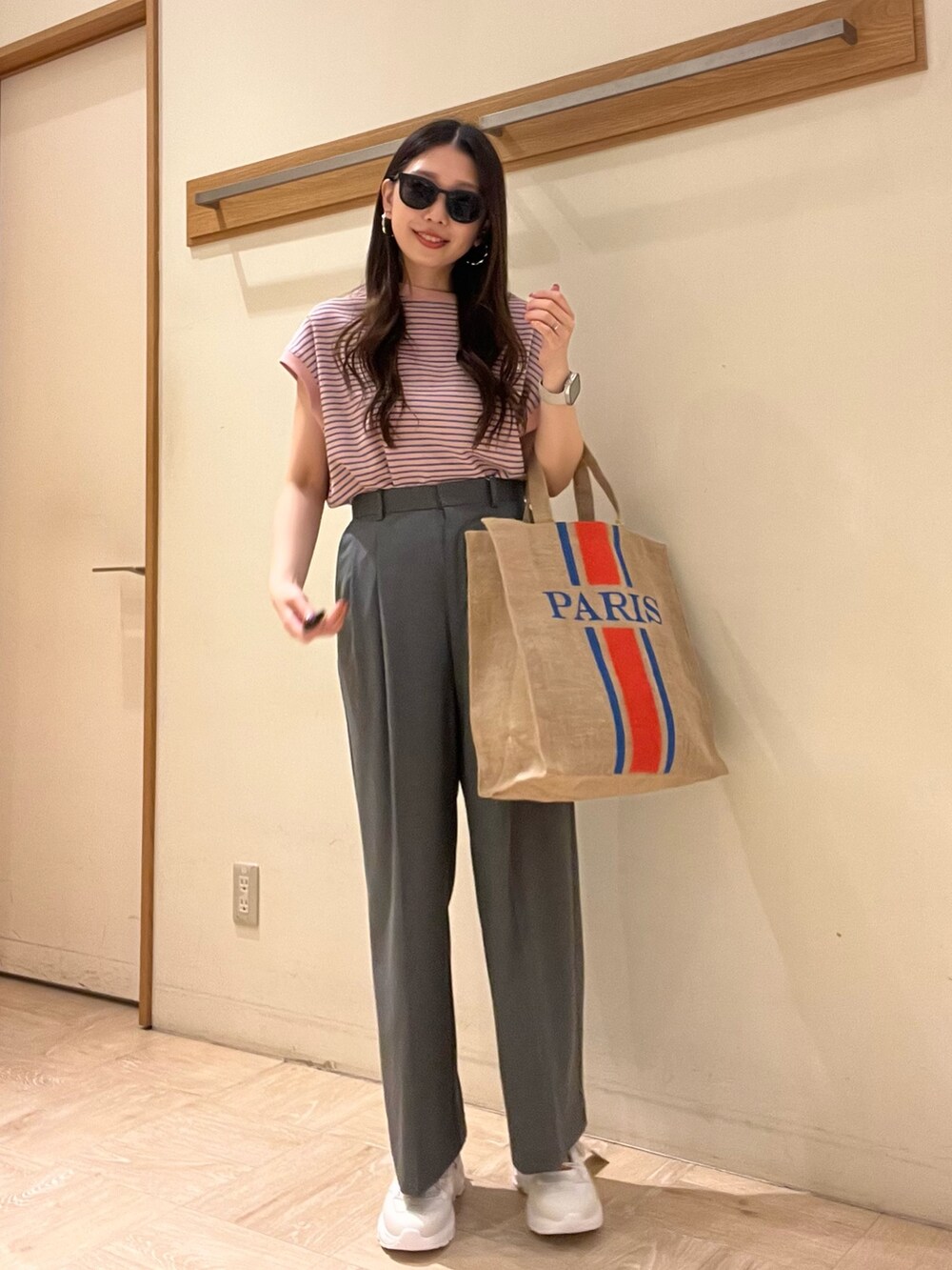 ホワイト系のTシャツ/カットソー、グレー系のスラックス、ブラック系のトートバッグを着用したレディースの夏コーディネートの3枚目の写真
