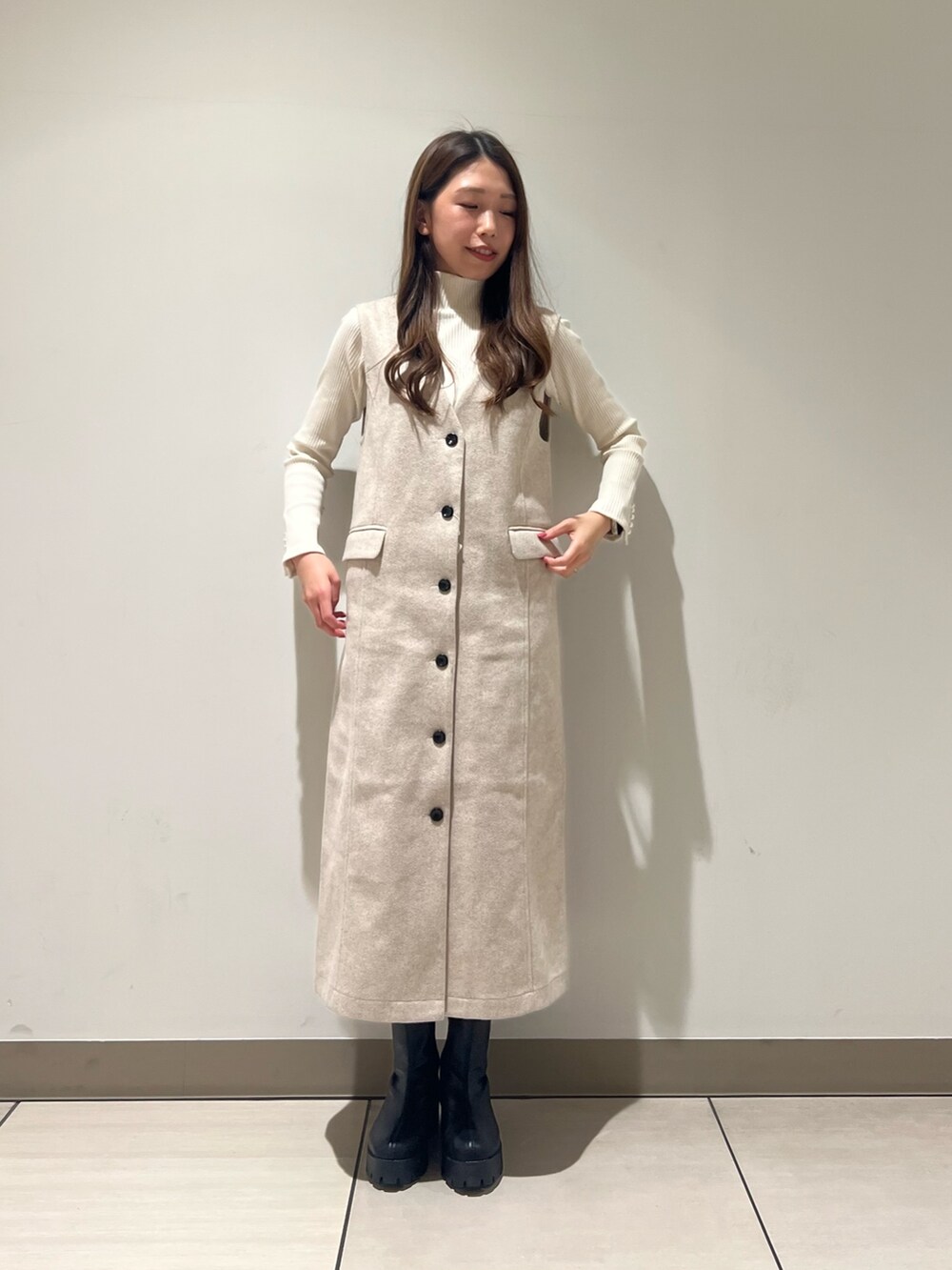 ホワイト系のTシャツ/カットソー、ホワイト系のジャンパースカートを着用したレディースの冬コーディネートの4枚目の写真