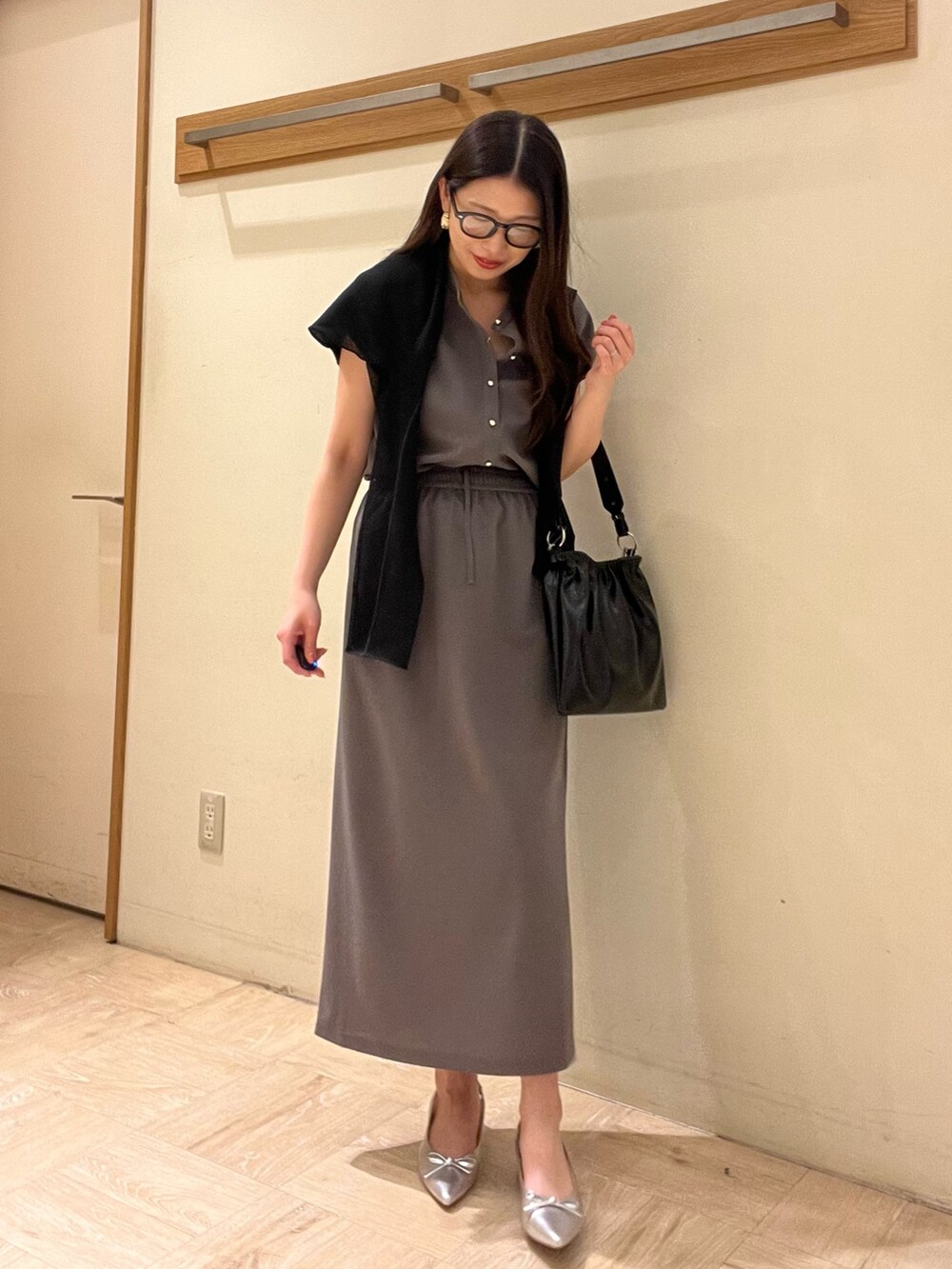 グレー系のシャツ/ブラウス、グレー系のスカート、ホワイト系のショルダーバッグを着用したレディースの夏コーディネートの3枚目の写真