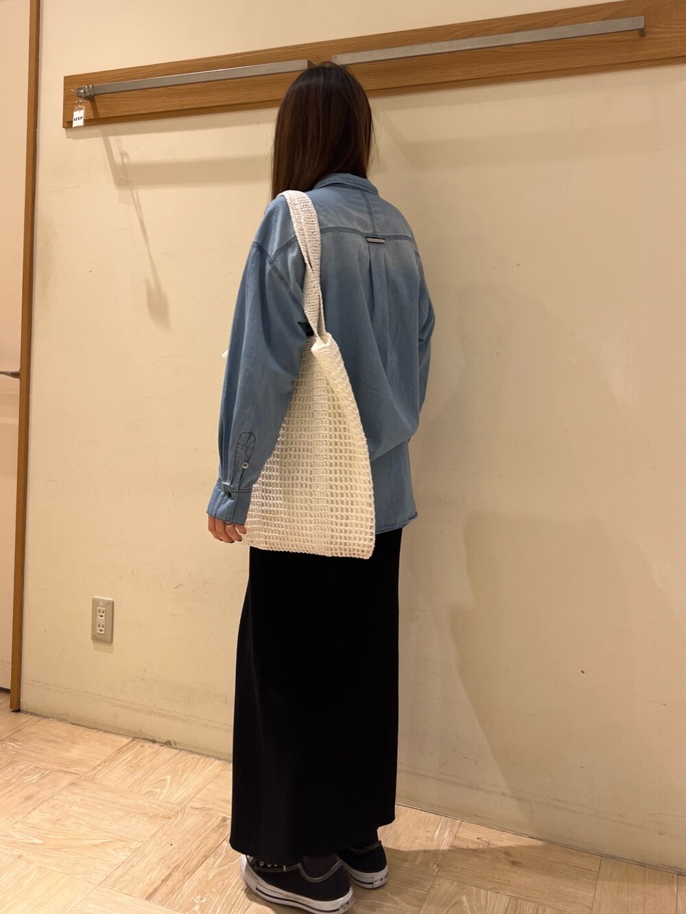 ブルー系のシャツ/ブラウス、ブラック系のスカート、ホワイト系のトートバッグを着用したレディースの春コーディネートの2枚目の写真