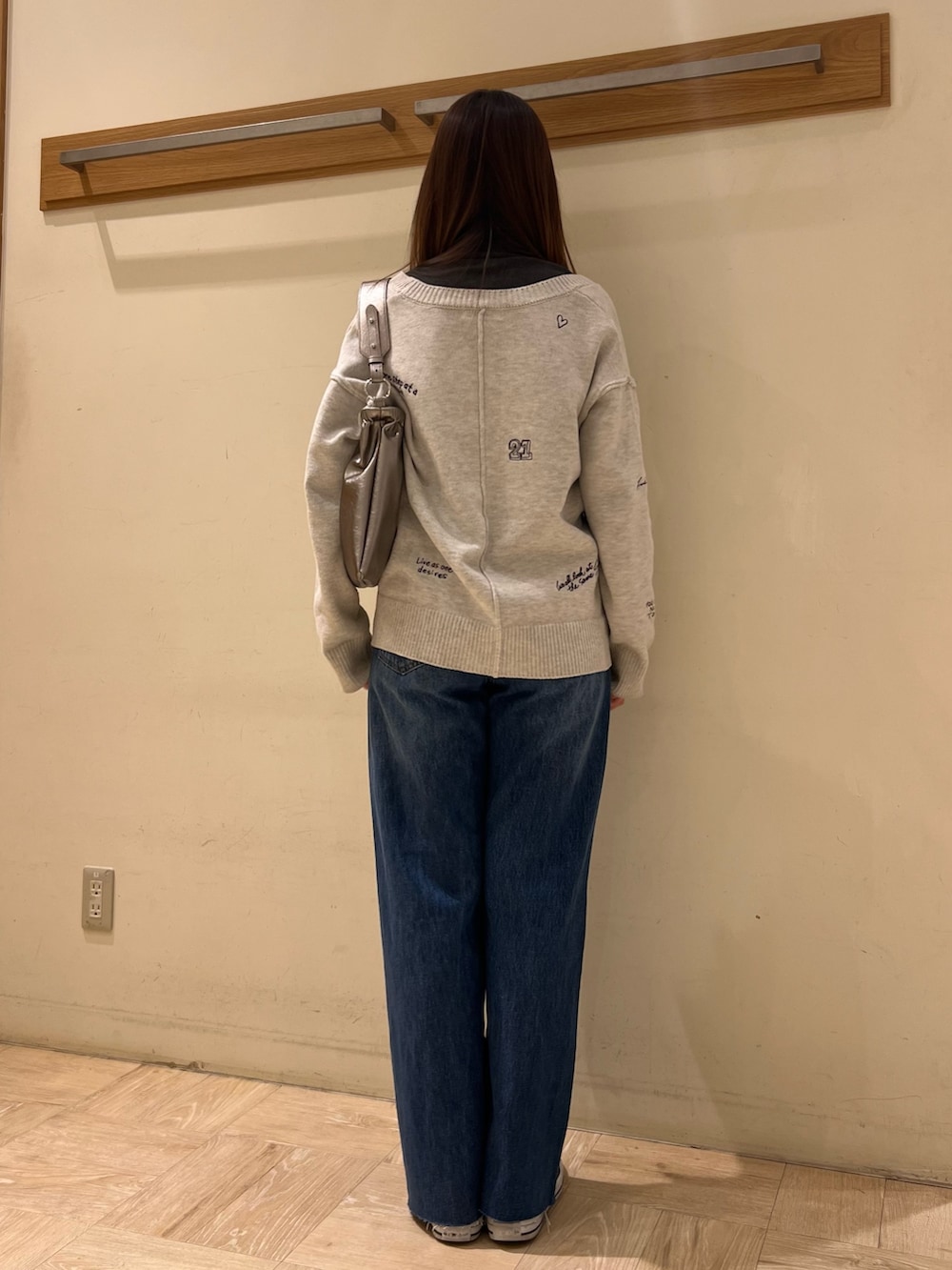 ホワイト系のカーディガン/ボレロ、ブルー系のデニムパンツ、その他のショルダーバッグを着用したレディースの冬コーディネートの5枚目の写真