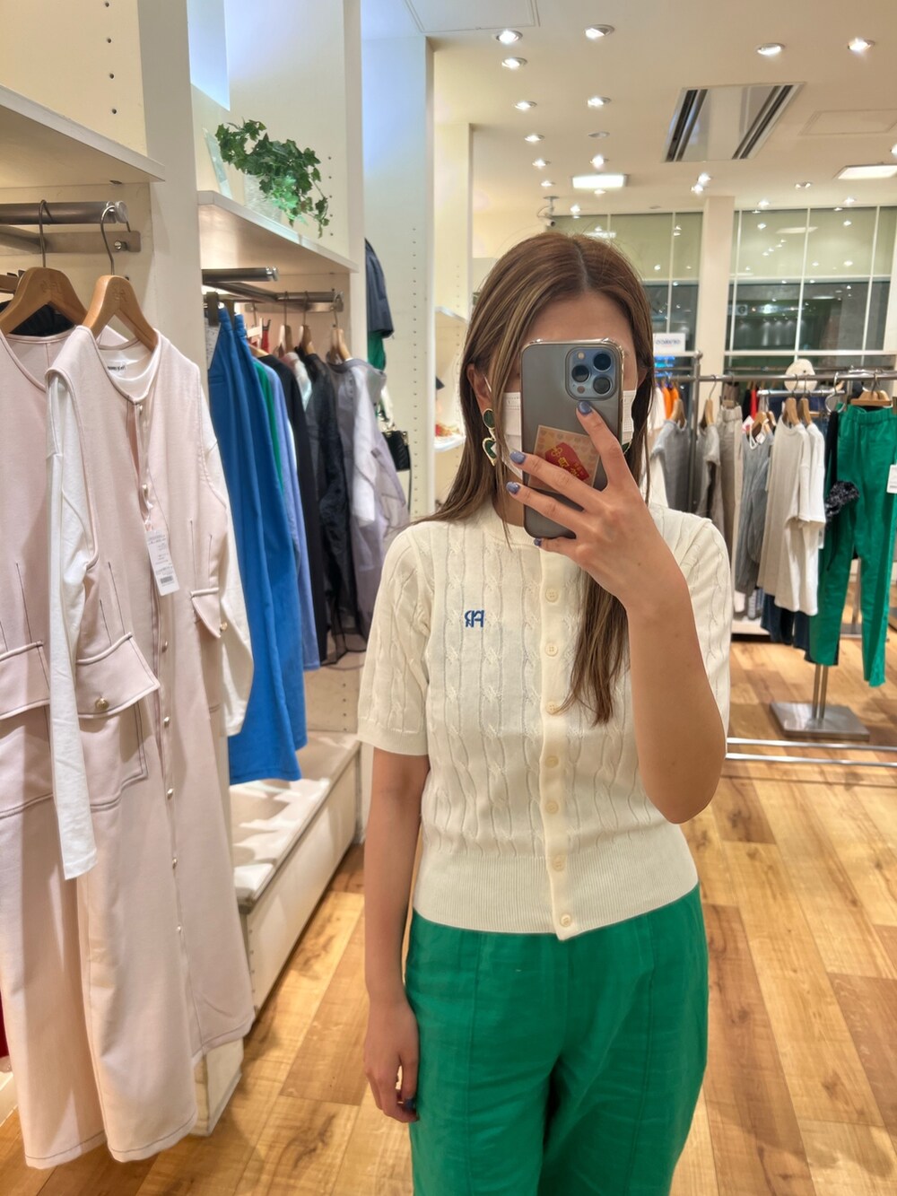 ホワイト系のカーディガン/ボレロ、ブラック系のキャミソール、グリーン系のその他パンツを着用したレディースの春コーディネートの2枚目の写真