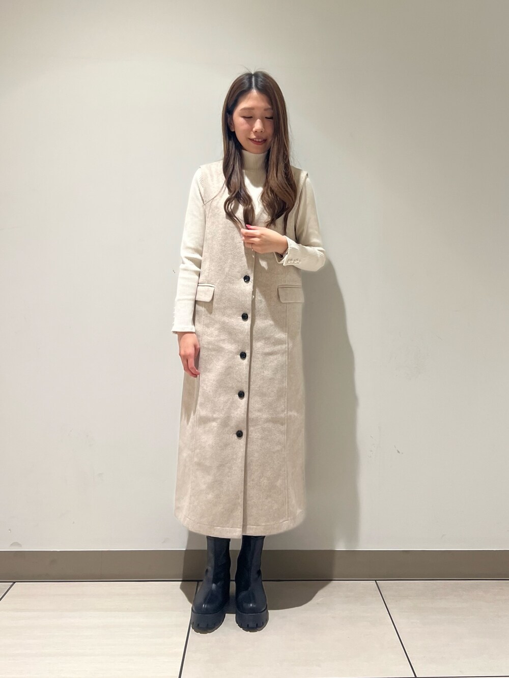 ホワイト系のTシャツ/カットソー、ホワイト系のジャンパースカートを着用したレディースの冬コーディネートの3枚目の写真