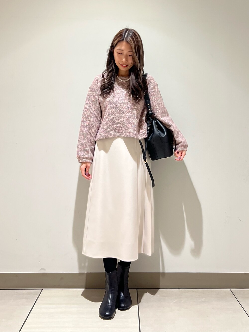 ホワイト系のスカート、パープル系のTシャツ/カットソーを着用したレディースの冬コーディネートの2枚目の写真