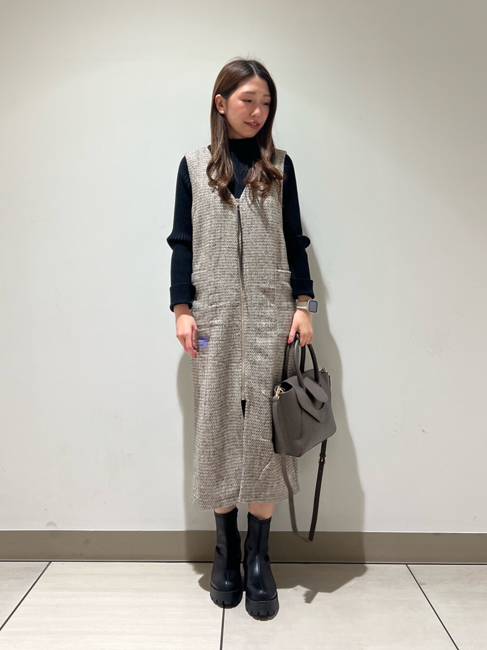 ベージュ系のワンピース、ブラック系のニット/セーターを着用したレディースの冬コーディネートの3枚目の写真