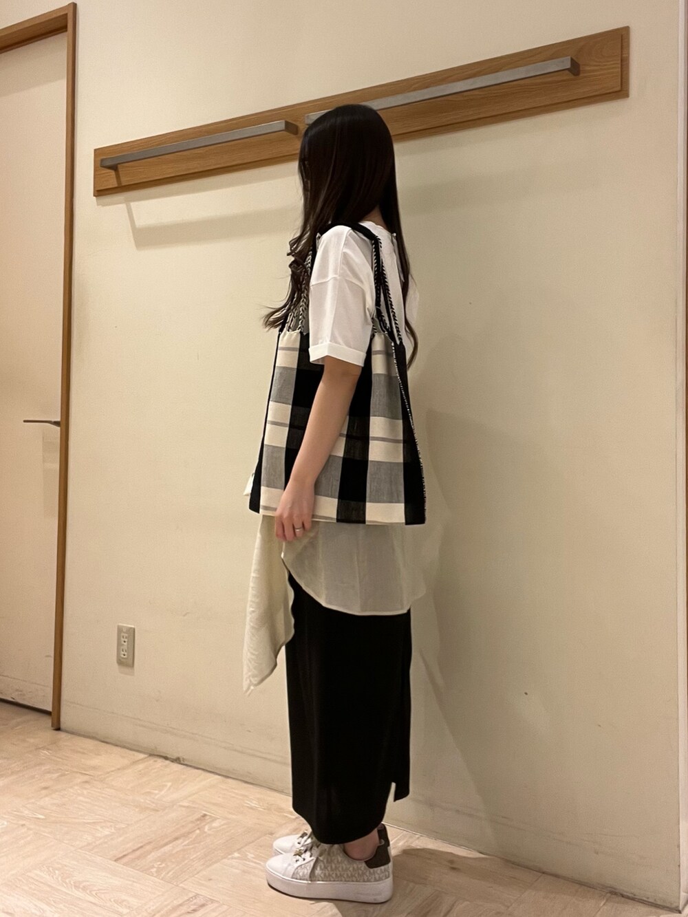 ホワイト系のTシャツ/カットソー、ブラック系のトートバッグ、ブラック系のスカートを着用したレディースの夏コーディネートの4枚目の写真