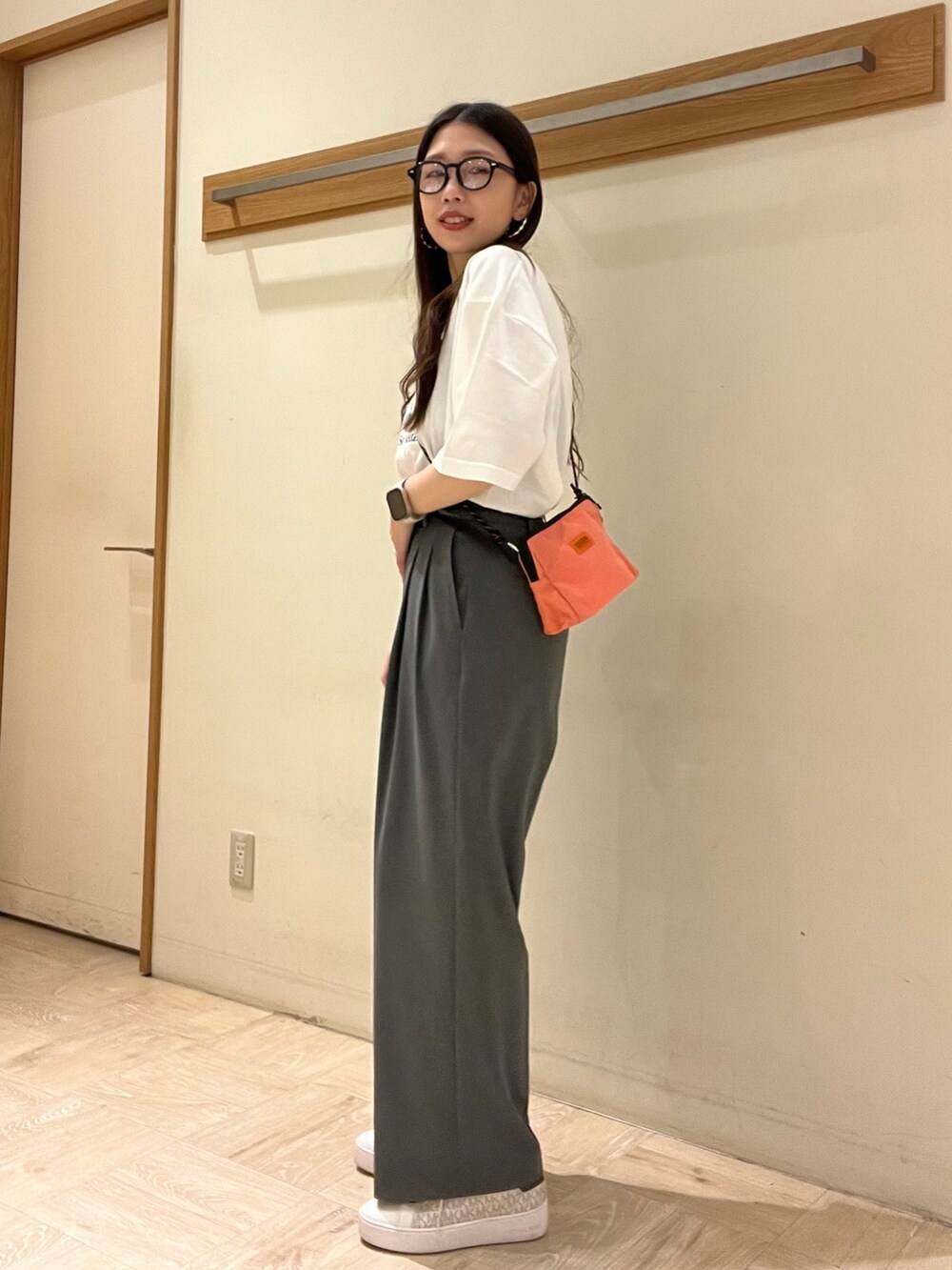 ピンク系のショルダーバッグ、ホワイト系のTシャツ/カットソー、グレー系のスラックスを着用したレディースの夏コーディネートの3枚目の写真