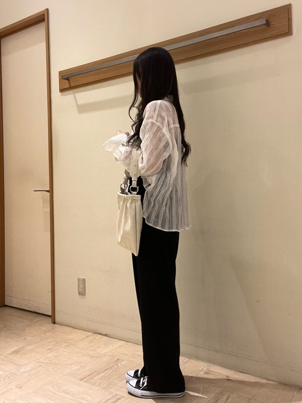 ホワイト系のショルダーバッグ、ブラック系のスラックス、ホワイト系のシャツ/ブラウスを着用したレディースの春コーディネートの2枚目の写真