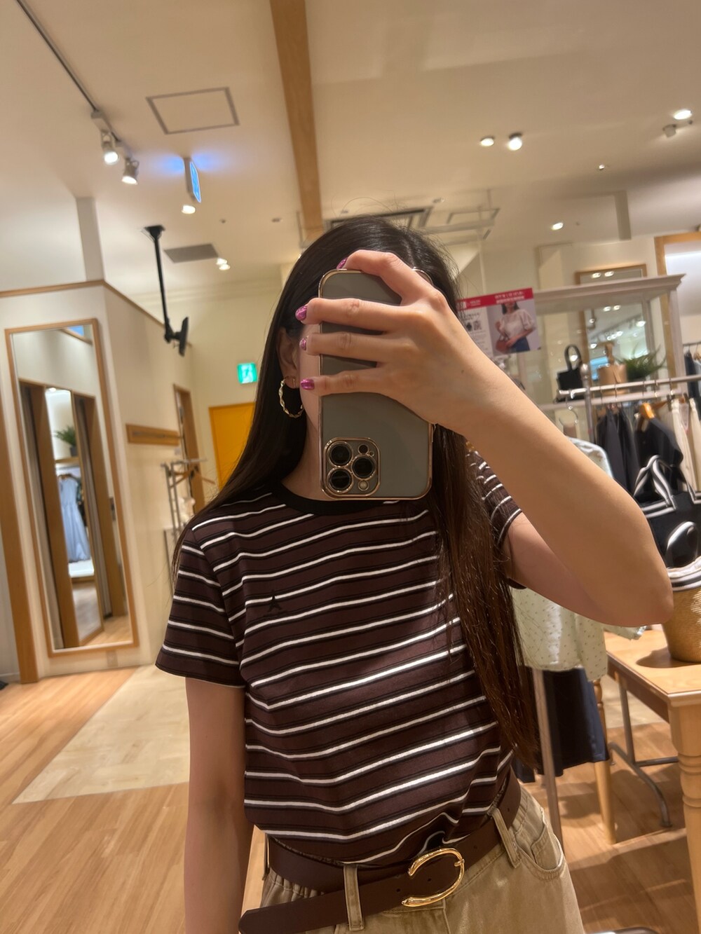 ベージュ系のTシャツ/カットソー、ベージュ系のデニムパンツ、ブラウン系のベルトを着用したレディースの夏コーディネートの2枚目の写真