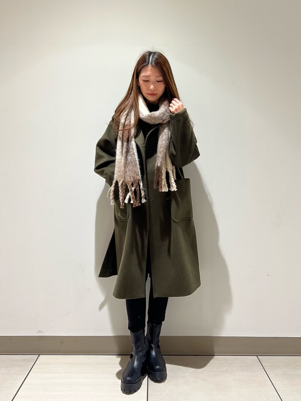 グリーン系のその他アウター、ブルー系のTシャツ/カットソー、ベージュ系のストール/ショールを着用したレディースの冬コーディネートの4枚目の写真