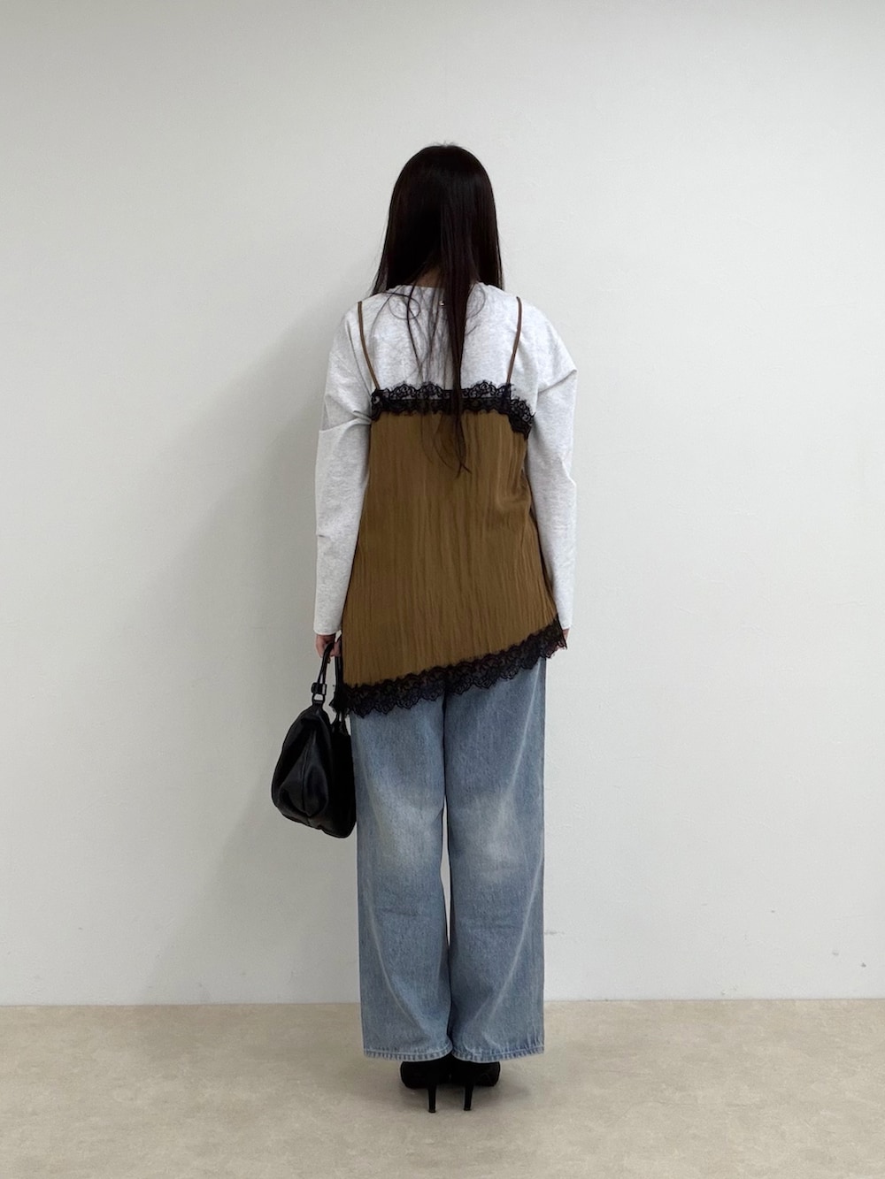 イエロー系のTシャツ/カットソー、ブルー系のデニムパンツを着用したレディースの秋コーディネートの3枚目の写真