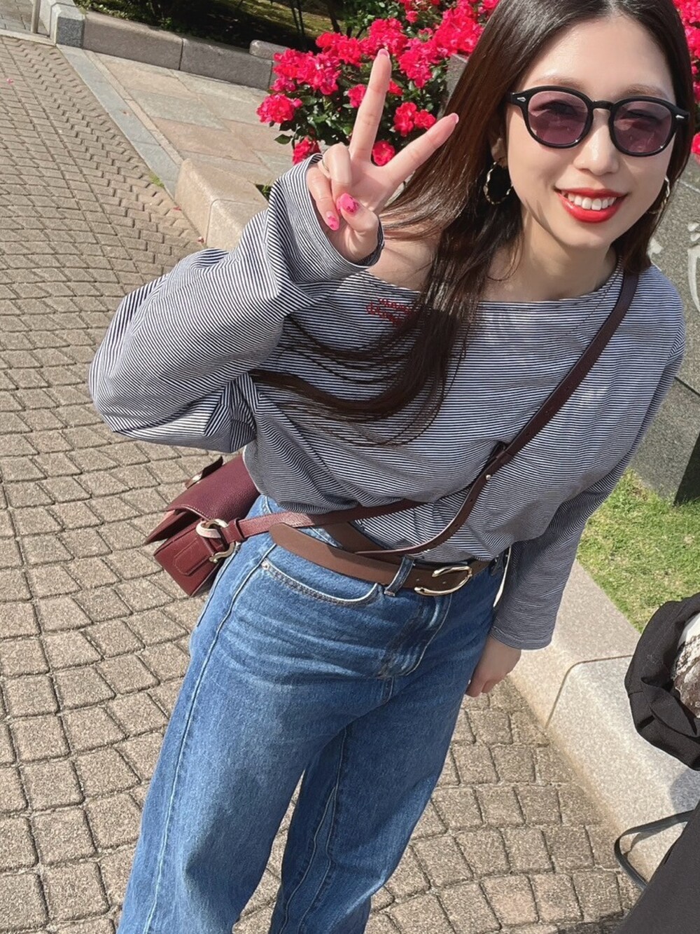 ホワイト系のTシャツ/カットソー、ブルー系のデニムパンツを着用したレディースの春コーディネートの2枚目の写真