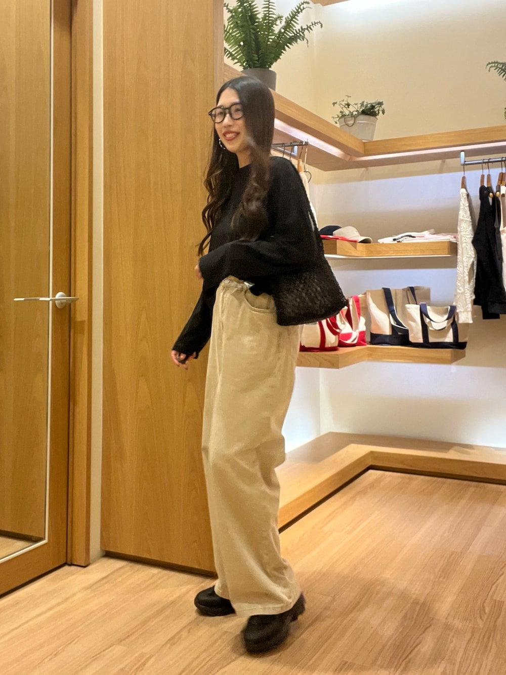 ブラック系のTシャツ/カットソー、ベージュ系のデニムパンツ、ブラック系のサングラスを着用したレディースの夏コーディネートの3枚目の写真