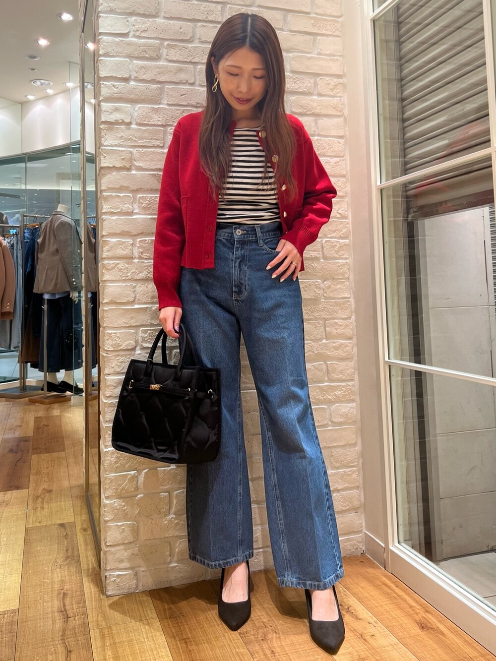 レッド系のカーディガン/ボレロ、ブラック系のTシャツ/カットソー、ブラック系のトートバッグを着用したレディースの秋コーディネートの2枚目の写真