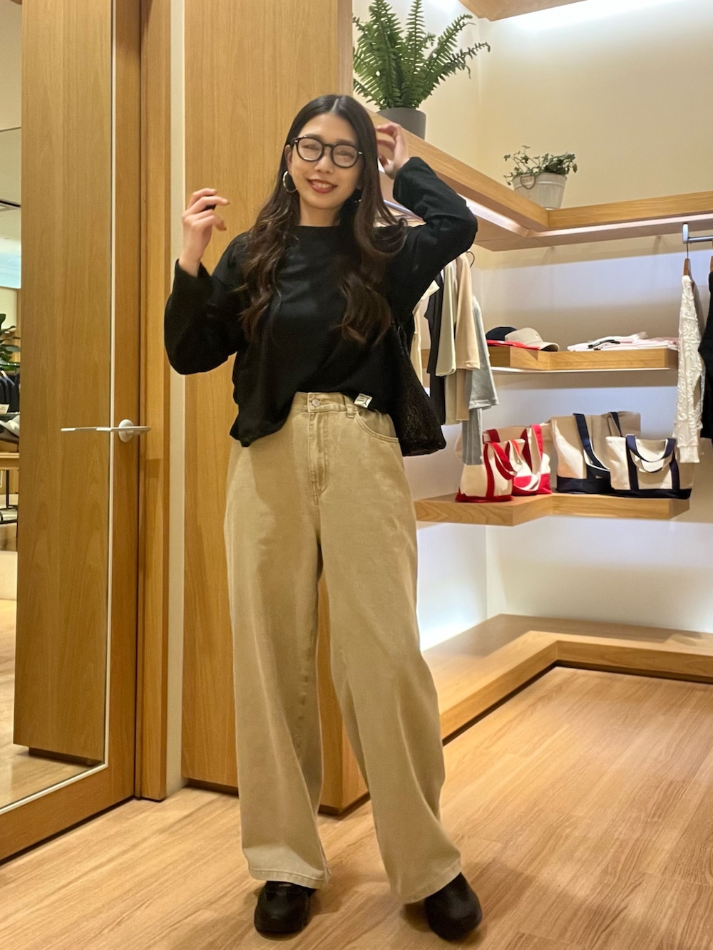 ブラック系のTシャツ/カットソー、ベージュ系のデニムパンツ、ブラック系のサングラスを着用したレディースの夏コーディネートの2枚目の写真