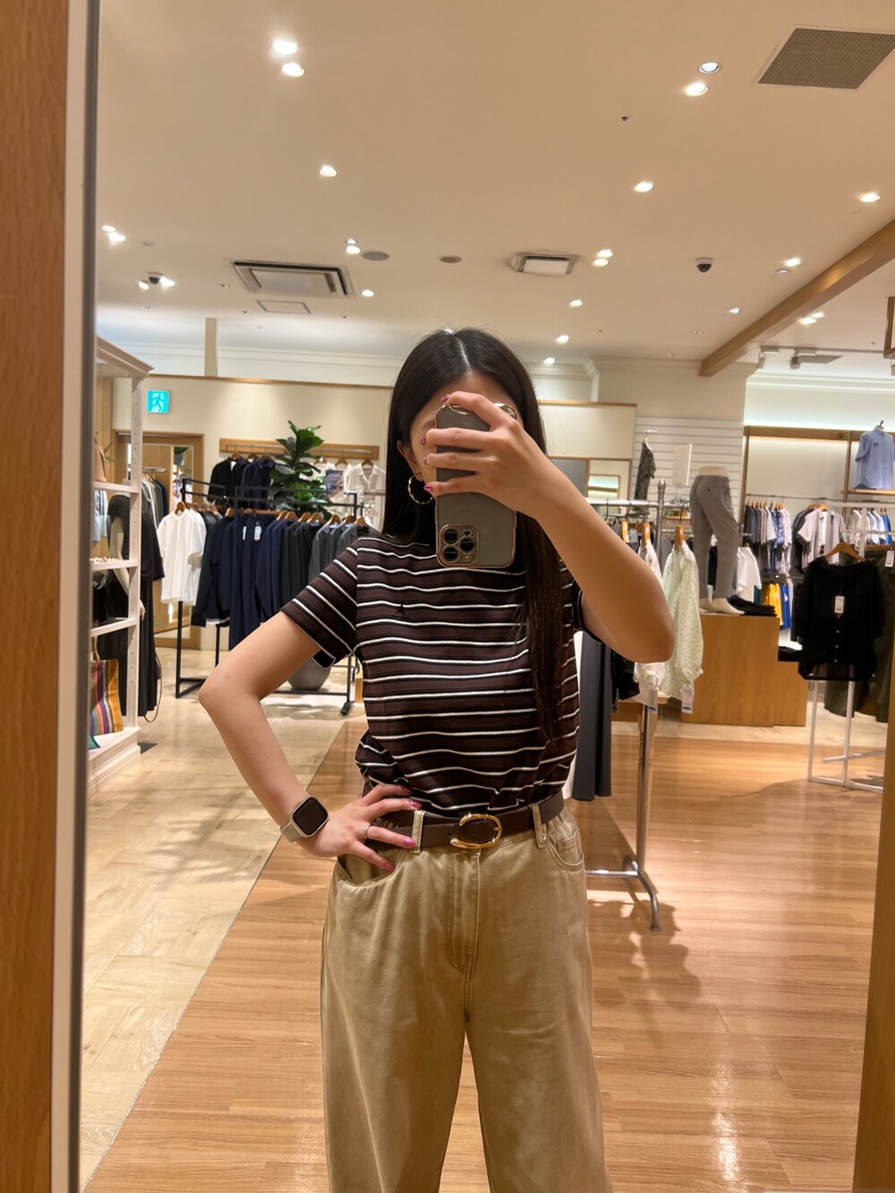 ベージュ系のTシャツ/カットソー、ベージュ系のデニムパンツ、ブラウン系のベルトを着用したレディースの夏コーディネートの6枚目の写真