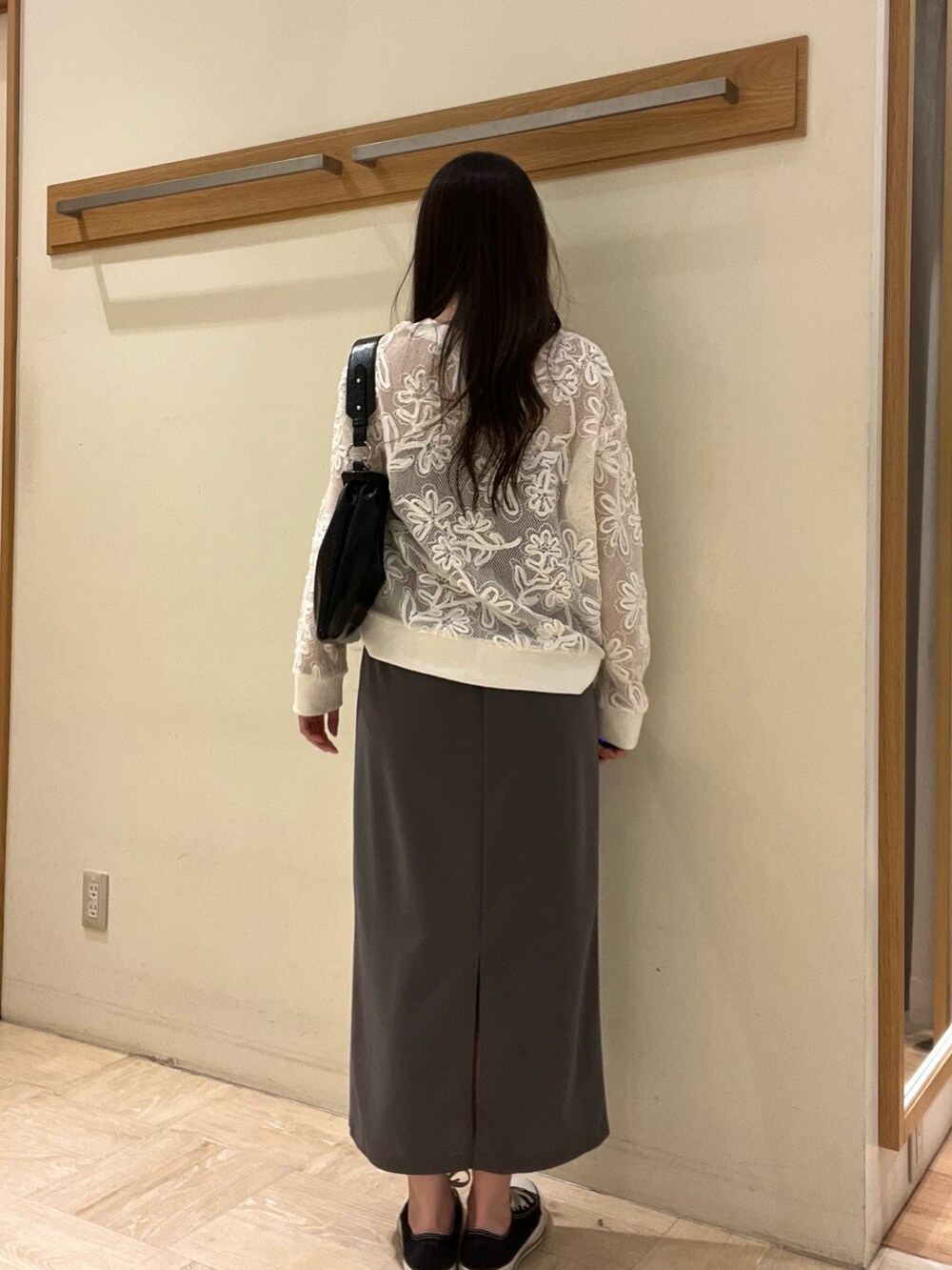 グレー系のスカート、ホワイト系のカーディガン/ボレロ、ブラック系のショルダーバッグを着用したレディースの春コーディネートの5枚目の写真