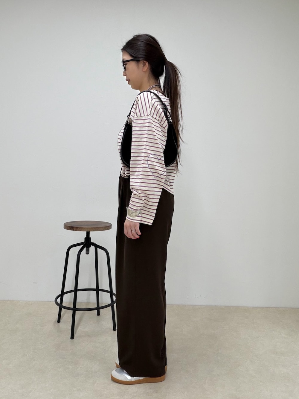 ピンク系のTシャツ/カットソー、ブラウン系のその他パンツ、シルバー系のスニーカーを着用したレディースの春コーディネートの2枚目の写真