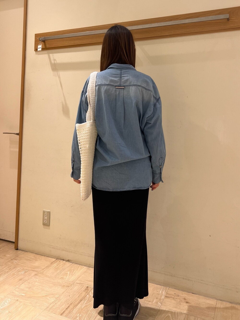 ブルー系のシャツ/ブラウス、ブラック系のスカート、ホワイト系のトートバッグを着用したレディースの春コーディネートの3枚目の写真