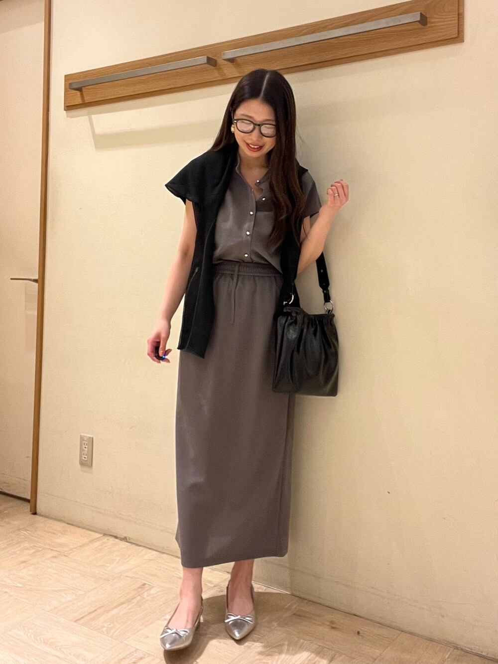 グレー系のシャツ/ブラウス、グレー系のスカート、ホワイト系のショルダーバッグを着用したレディースの夏コーディネートの2枚目の写真