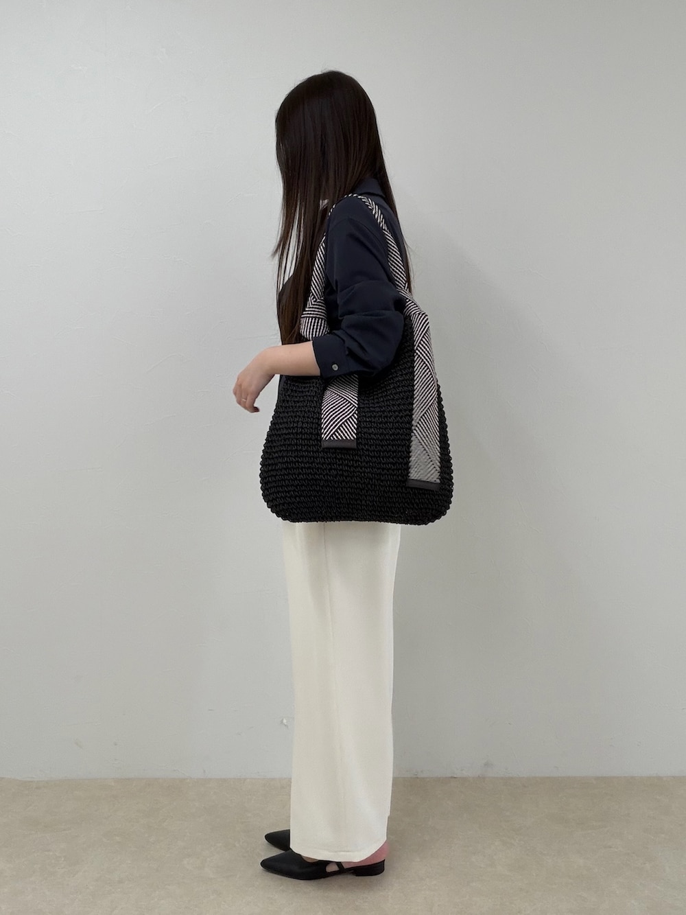 ブルー系のシャツ/ブラウス、ホワイト系のその他パンツ、ブラック系のトートバッグを着用したレディースの春コーディネートの2枚目の写真