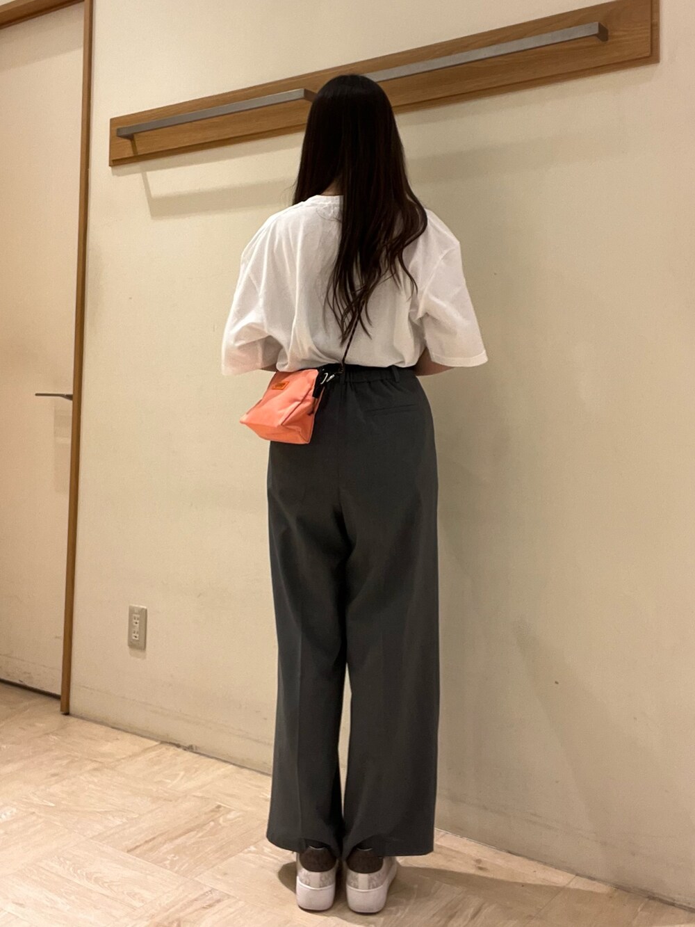 ピンク系のショルダーバッグ、ホワイト系のTシャツ/カットソー、グレー系のスラックスを着用したレディースの夏コーディネートの6枚目の写真