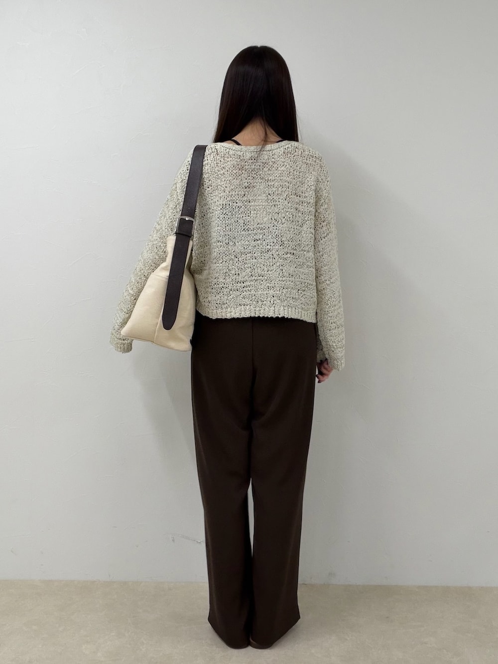 ベージュ系のニット/セーター、ブラウン系のその他パンツ、ホワイト系のショルダーバッグを着用したレディースの春コーディネートの4枚目の写真