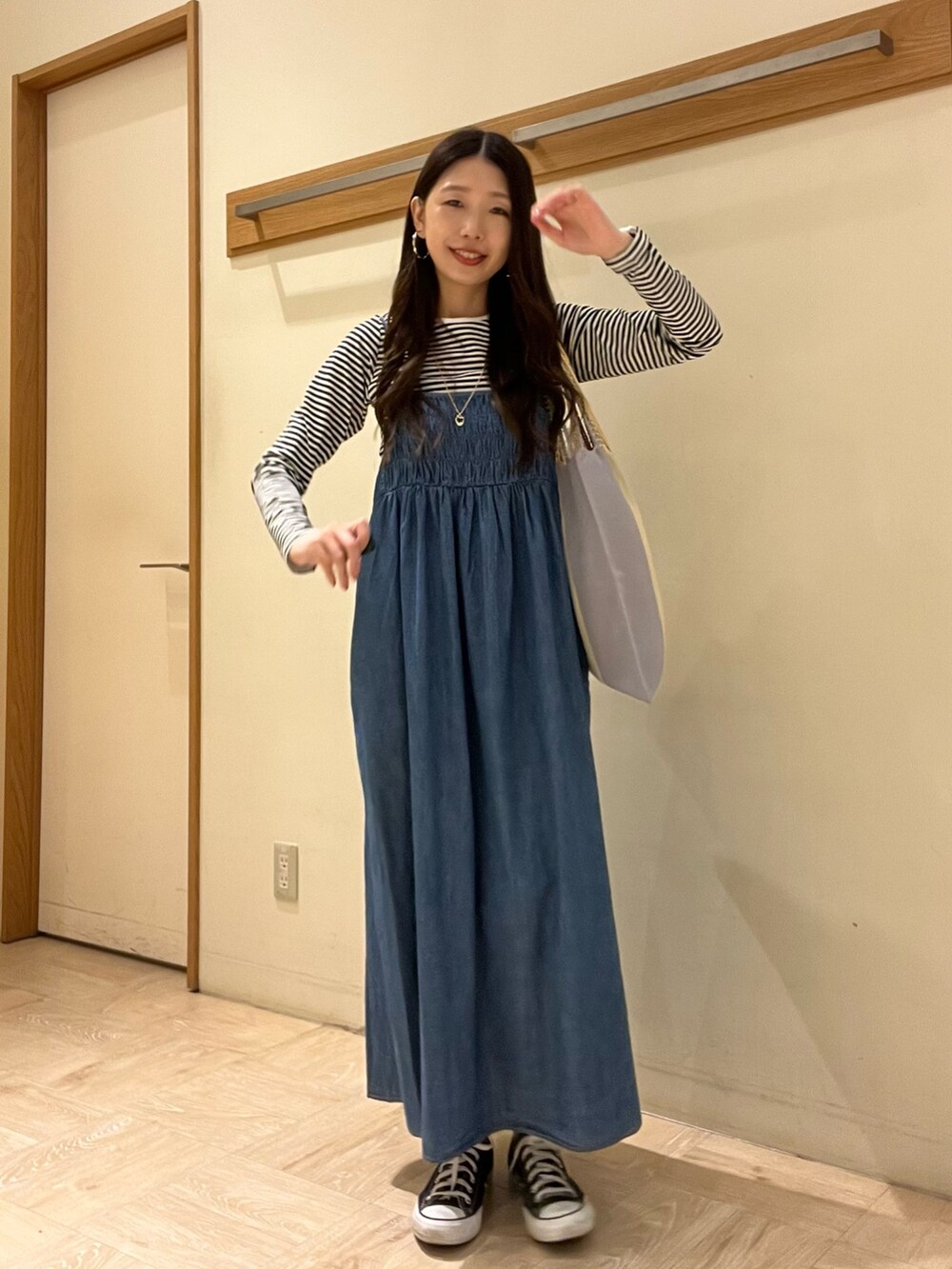 ブラウン系のトートバッグ、ホワイト系のTシャツ/カットソー、ブルー系のワンピースを着用したレディースの春コーディネートの2枚目の写真