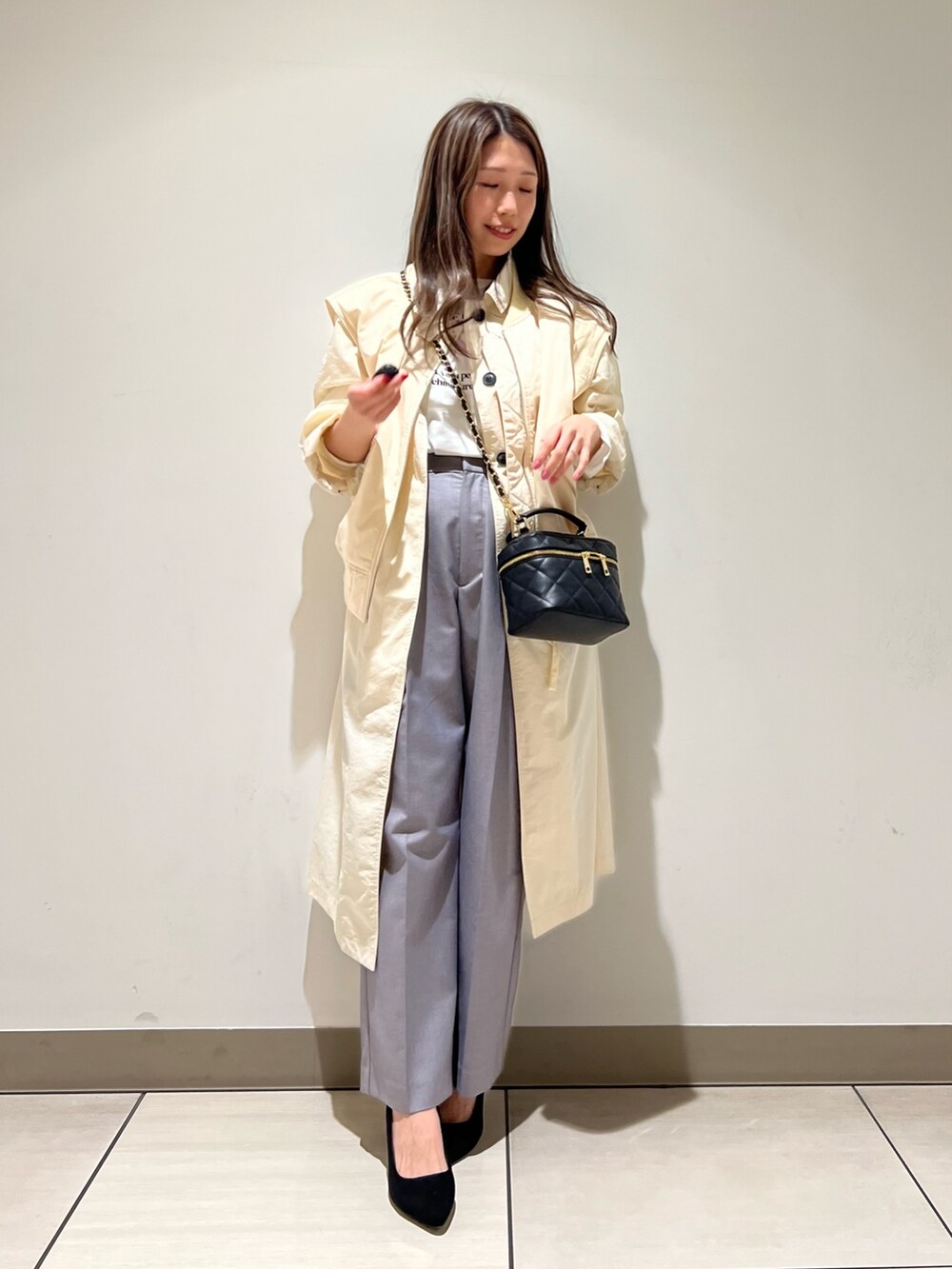 グリーン系のステンカラーコート、グリーン系のブルゾン、ホワイト系のTシャツ/カットソーを着用したレディースの冬コーディネートの2枚目の写真