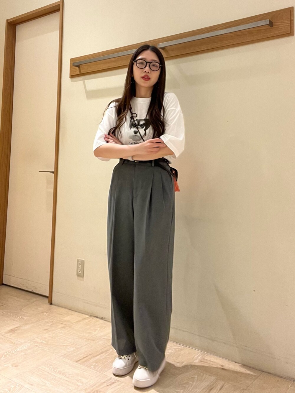 ピンク系のショルダーバッグ、ホワイト系のTシャツ/カットソー、グレー系のスラックスを着用したレディースの夏コーディネートの4枚目の写真